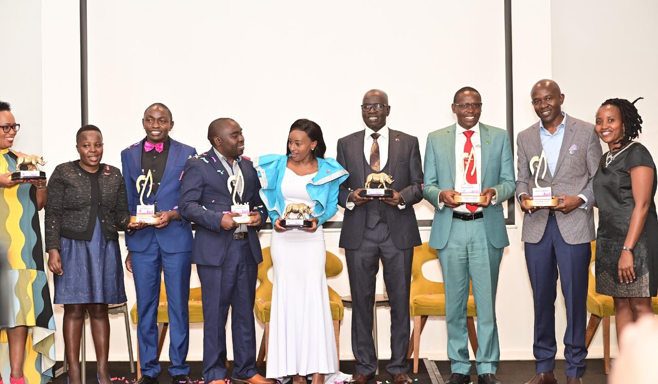Award recipients holding their trophies on stage at a previous PurposeFest