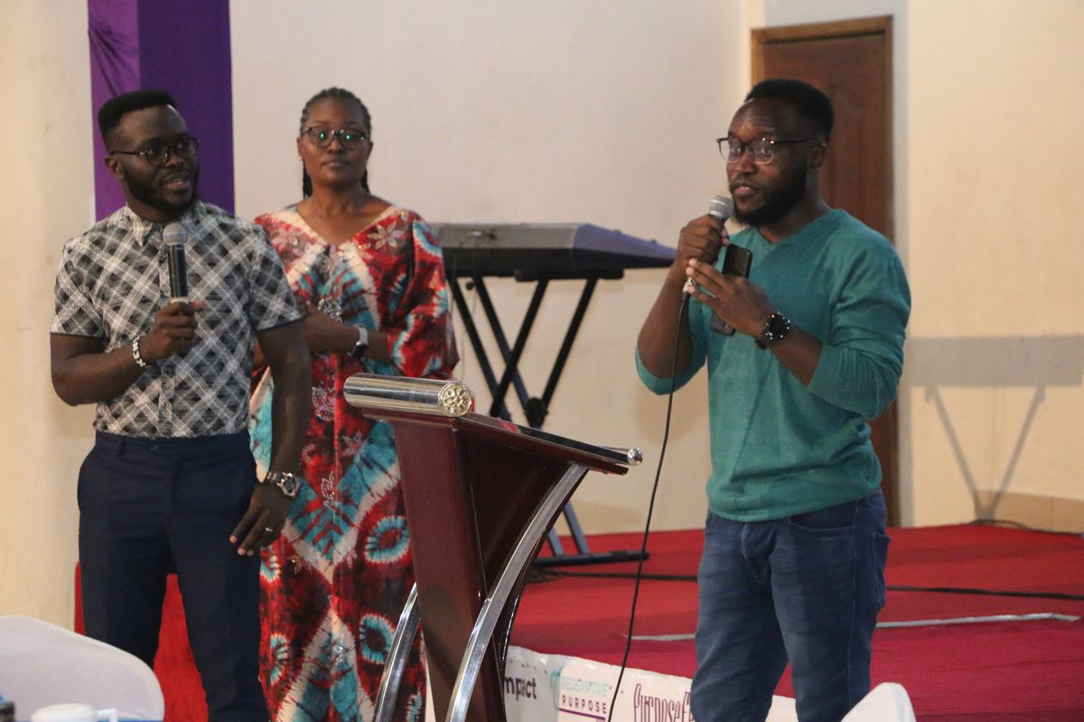 Hosts leading a session from the lectern at PurposeFest 2023