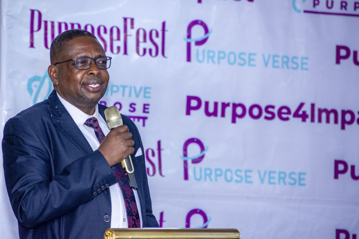 A speaker at the PurposeFest backdrop, 2024