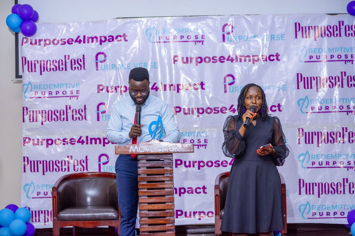 Two hosts at the lectern in front of the Purpose4Impact backdrop, 2025